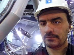 Алексей Паевский на фоне зеркала телескопа Анту